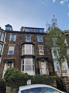 un edificio de ladrillo con un coche aparcado delante de él en Townhouse - 6 Bed Hot Tub House, en Bowness-on-Windermere
