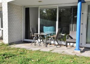 a patio with a table and chairs on a porch at Appartement Badhotel 301 in Callantsoog
