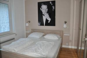 a bed in a room with a picture on the wall at Appartement Badhotel 301 in Callantsoog
