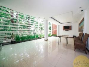 eine Lobby mit einem Tisch, Stühlen und Pflanzen in der Unterkunft Excellent Seven Hotel by My Hospitality in Bandung