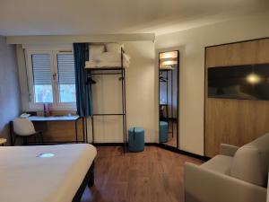 een hotelkamer met een bed, een tafel en een bureau bij ibis Chateauroux in Châteauroux