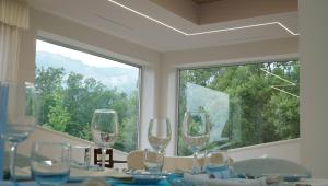 una mesa con copas de vino y una gran ventana en Hotel Palace Savuto, en Malito