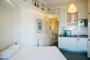 リスボンにあるApartamento acolhedor com vista Castelo de São Jorge - TTL308の白いベッドルーム(ベッド1台付)、キッチンが備わります。