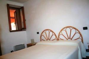 a bedroom with a white bed and a mirror at Quinta holiday residence in Rio nell'Elba in Rio nellʼElba