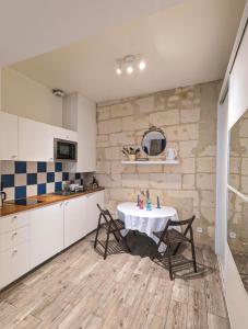 cocina con mesa y sillas en una habitación en Lurbe Bleue - Bordeaux central et calme, en Burdeos