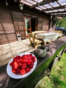 een bord aardbeien op een tafel op een houten tafel bij Elixír Guest House in Izvoare