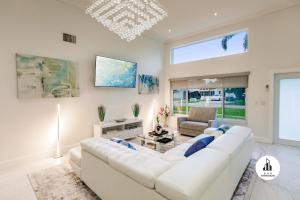 - un salon blanc avec un canapé et des fauteuils blancs dans l'établissement Bnb Hyperion - 5BR 3BA Home w Pool, Lounge & Deck, à Miami