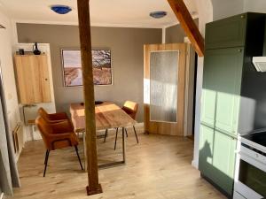 a kitchen with a table and chairs in a room at Schnitterkaserne in Schaprode 7B in Schaprode