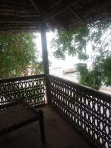 a balcony with a bench and a view of a street at Seafront House in Lamu