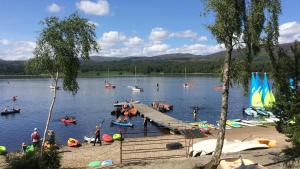 a group of people in the water at a dock at Loch Insh Chalets Ltd in Kincraig