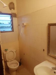 a bathroom with a toilet and a sink and a mirror at Seafront House in Lamu