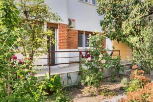 a house with a porch with flowers in the yard at Happy Home - Rental Residence in Split