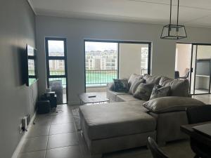 a living room with a couch and a table at Lagoon Facing Apartment in Midrand