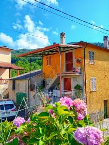 una casa colorida con flores delante en Agriturismo Ghirlanda Norma Rita, en Carrodano Inferiore