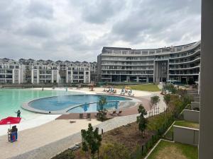 a large apartment building with a large swimming pool at Lagoon Facing Apartment in Midrand