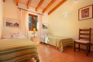 een slaapkamer met 2 bedden en een stoel bij La Salve dalt in Pollença