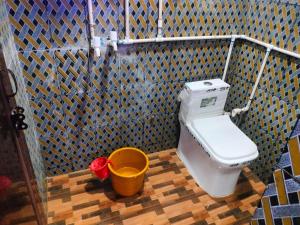 a small bathroom with a toilet and a bucket at Annu Bhai sewa sadan in Mathura