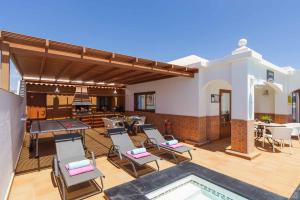 a patio with a bunch of chairs and a pool at Villa Palina in Puerto del Carmen