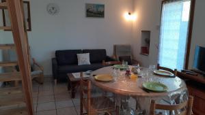 uma sala de estar com uma mesa e um sofá em maisonnette le cabanon em Sainte-Jalle