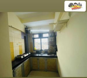 a small kitchen with a sink and a window at Santacruz east in Mumbai