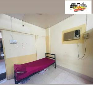 Habitación con cama y aire acondicionado. en Santacruz east, en Bombay