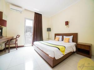 Schlafzimmer mit einem Bett, einem Schreibtisch und einem Fenster in der Unterkunft Excellent Seven Hotel by My Hospitality in Bandung