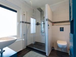 ein Bad mit einer Dusche, einem WC und einem Waschbecken in der Unterkunft Familiekamer B&B Gezond Aan Zee, 3 persoons, meerprijs voor wellness in Ouddorp