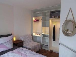 - une chambre avec un lit, un canapé et un miroir dans l'établissement Ferienwohnung Kapitänshus, 25668, à Weener