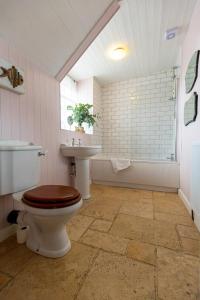 a bathroom with a toilet and a sink at Church Cottage by Coast & Country Stays in Beadnell +40 photos