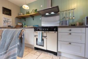 a kitchen with a stove top oven in a kitchen at Church Cottage by Coast & Country Stays in Beadnell +45 photos