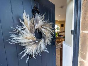 a blue door with a wreath on it at Church Cottage by Coast & Country Stays in Beadnell