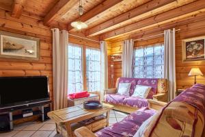 a living room with a couch and a tv at Chalet le Serac in Gresse-en-Vercors