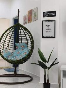 a bird cage sitting next to a plant in a room at ARAH Homestay @ Kuhara Court Tawau in Tawau