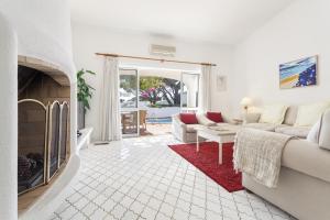 Una sala de estar con un sofá y una chimenea. en Villa Rosa, en Vale do Lobo
