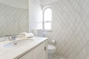Un baño blanco con lavabo e inodoro. en Villa Rosa, en Vale do Lobo 8 fotos más