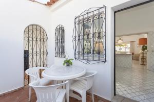 Un comedor blanco con una mesa y sillas blancas. en Villa Rosa, en Vale do Lobo