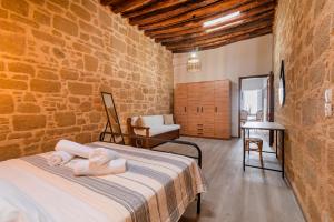 a bedroom with a bed in a brick wall at Manolis and Anna's House in Malona Village