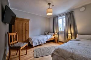 a bedroom with two beds and a tv and a chair at Boutique-Hotel am Ledererturm in Kelheim