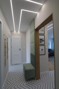 korytarz ze schodami z zieloną otomaną w obiekcie Słodowiec Residence /medium Żoliborz Bielany/ w Warszawie