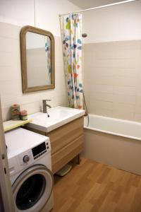 een badkamer met een wasmachine en een wastafel bij Chez Catherine in Fontenay-le-Fleury