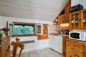 une cuisine avec des placards en bois et une fenêtre dans l'établissement Wild Valley Ticino Vista in Valle Onsernone, à Auressio