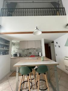 a kitchen with a wooden table and two green chairs at La Casa di Brunina - Serenità a un passo dal Centro in Monza