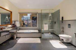a bathroom with a tub and a sink and a toilet at Moksha Himalaya Spa Resort in Kasauli