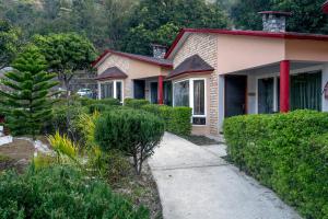 uma casa com um telhado vermelho e um passeio em LaTigre Resort em Tota Ām