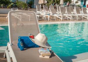 a hat sitting on a chair next to a swimming pool at Arena Beach in Corralejo