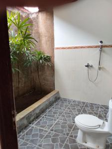 a bathroom with a toilet and a shower at Bayumantra Bungalows in Lovina