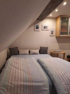 - une chambre mansardée avec un grand lit dans l'établissement Ferienwohnung Zum Lotsen, 45227, à Jemgum