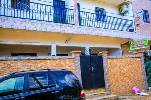 un todoterreno negro estacionado frente a un edificio en NAIVELI-PALM Appartement meublé sobre et chic, en Douala