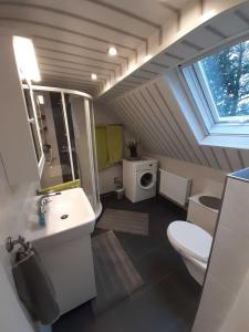 La salle de bains est pourvue d'un lavabo, de toilettes et d'une fenêtre. dans l'établissement Ferienwohnung Zum Lotsen, 45227, à Jemgum