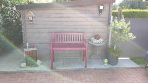 une chaise rose assise sur une table dans un jardin dans l'établissement Ferienwohnung Zum Lotsen, 45227, à Jemgum